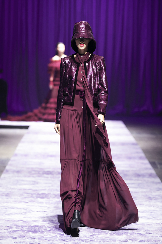Ngoài lụa mềm, vải xuyên thấu sexy, nhà thiết kế còn sử dụng vải ánh kim tông đỏ rượu chát để tạo nên các mẫu áo khoác hợp xu hướng.