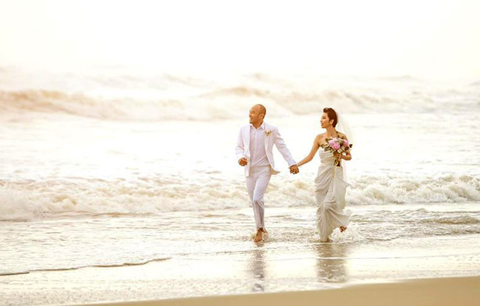 Cặp đôi tình tứ nắm tay nhau dạo chơi trên bãi biển Đà Nẵng.