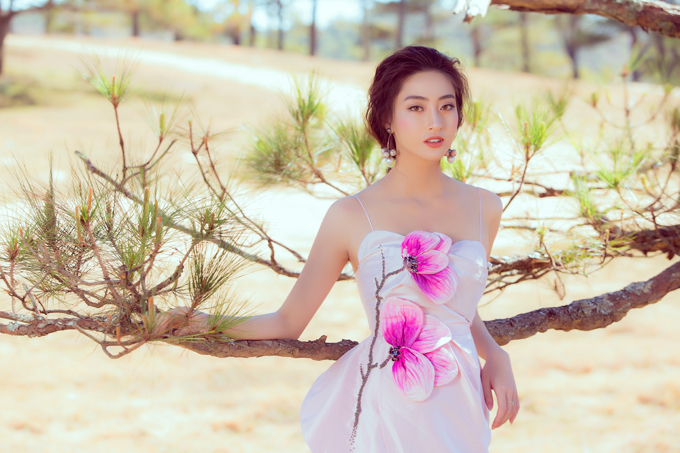 Váy dạ hội trang trí hoa mộc lan tôn màu rực rỡ được êkíp của hoa hậu Lương Thuỳ Linh chọn lựa để thực hiện bộ ảnh tại thành phố ngàn thông.